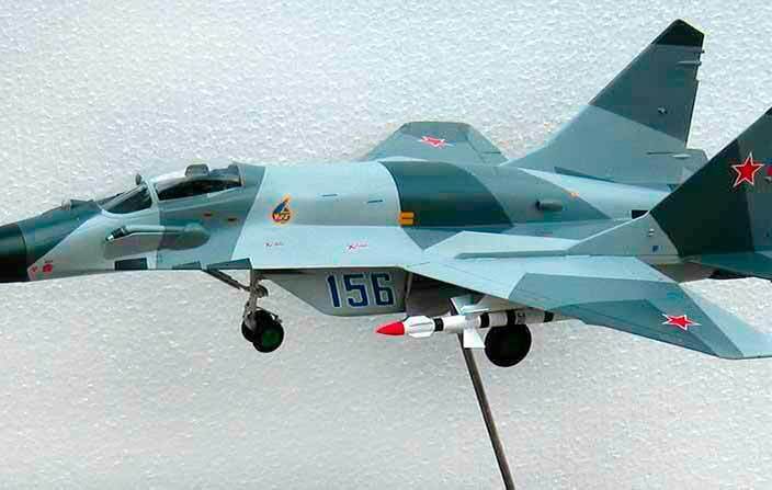 Масштабная модель истребителя МиГ‑29 в серо‑зелёном камуфляже на подставке Фотография масштабной модели российского истребителя МиГ‑29 в серо‑зелёном камуфляже с ракетами, установленной на подставке, вид сбоку