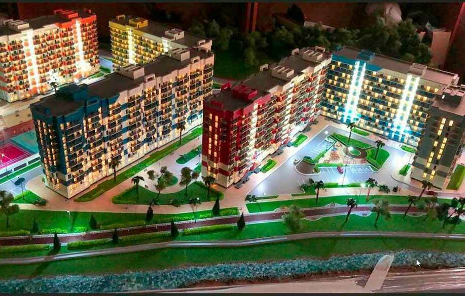 Макет жилого комплекса, выполненный на заказ для выставки Ночной архитектурный макет многоэтажного жилого комплекса с яркой подсветкой, парковкой, зелеными аллеями и набережной у воды