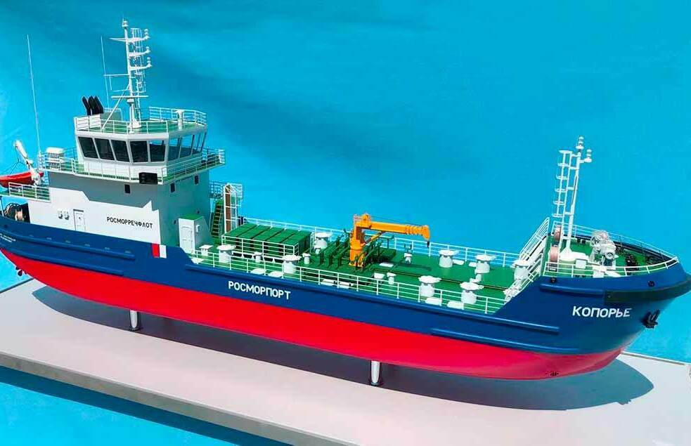 Макет судна / корабля на заказ. Макет многоцелевого служебного судна «Копорье» для Росморпорта Детализированный масштабный макет морского судна «Копорье» Росморпорт с палубным краном и надстройкой на синем фоне