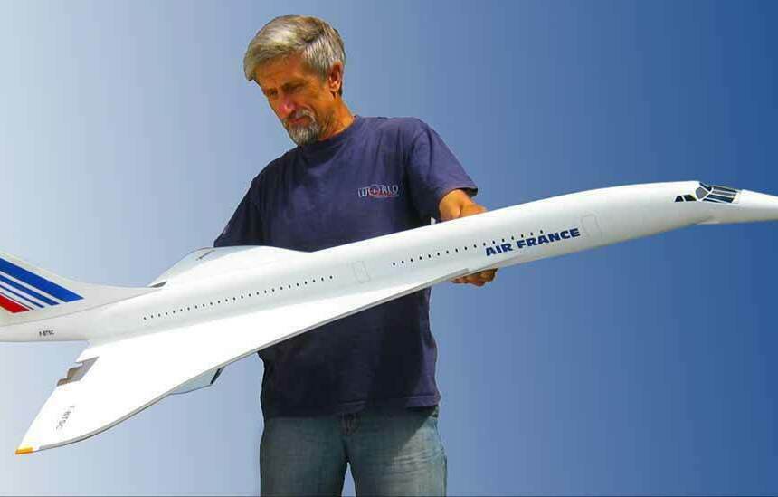 Макет современного самолёта на заказ. Масштабная модель самолёта Concorde Air France в руках моделиста Масштабный макет самолёта на заказ . Мужчина держит крупную масштабную модель сверхзвукового пассажирского самолёта Concorde авиакомпании Air France на фоне синего градиента