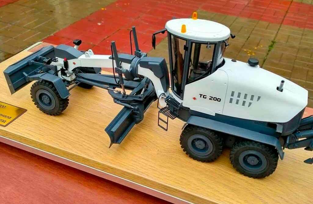 Масштабная модель автогрейдера ТС‑200 на деревянной подставке, изготовленная на заказ для выставки в г. Москва Детализированный макета автогрейдера ТС‑200, дорожно‑строительная техника на демонстрационной подставке