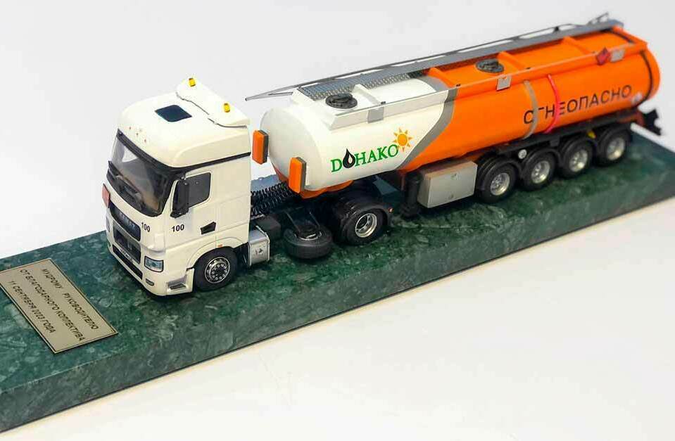 Макет бензовоза DONAKO на подставке – сувенирная модель автоцистерны Детализированная сувенирная модель бензовоза DONAKO с оранжевой автоцистерной «Огнеопасно» на мраморной подставке с табличкой, корпоративный подарочный макет грузовика