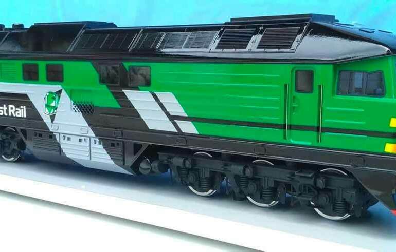 Масштабная модель зелёного тепловоза Skinest Rail на подставке . Модель локомотива. Макет железнодорожного транспорта Детализированный макет зелёного тепловоза Skinest Rail с логотипом на борту, установленного на белой подставке